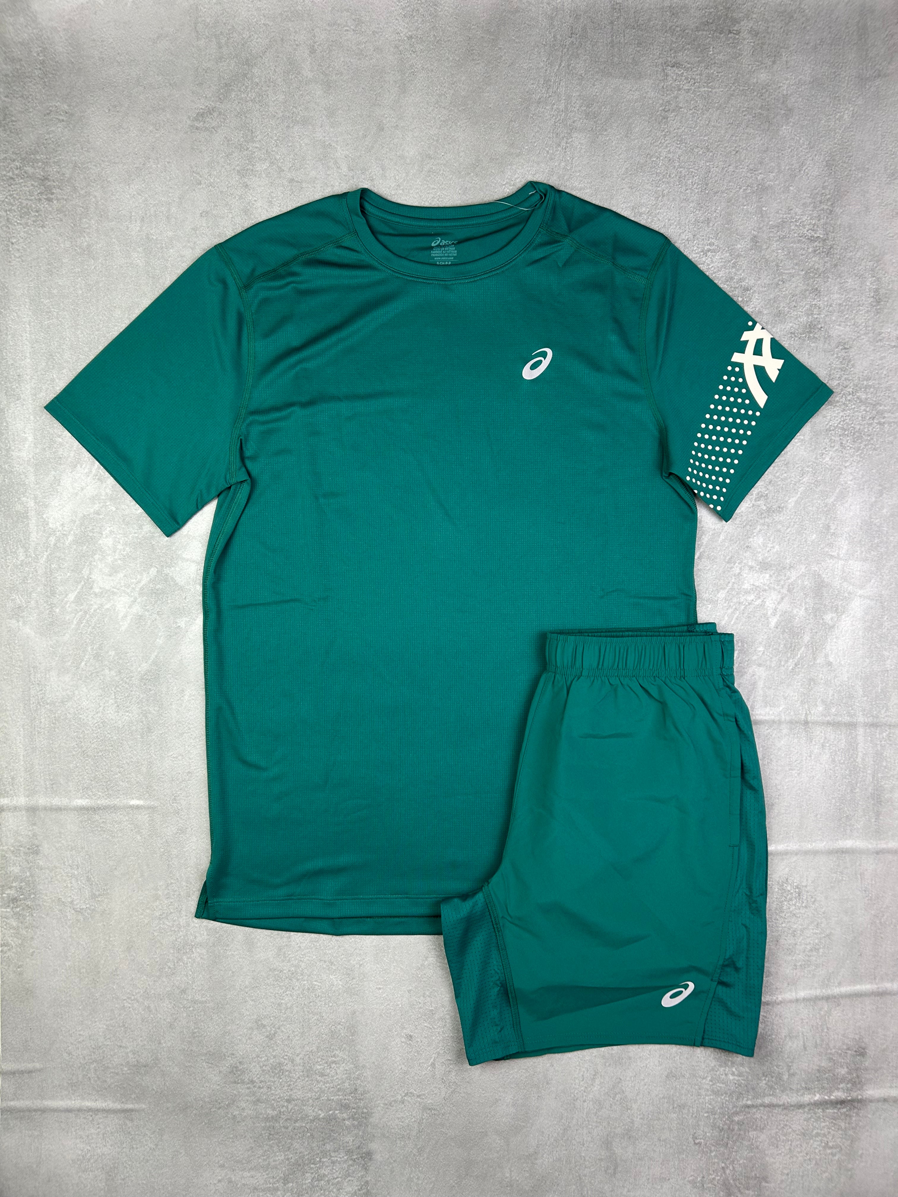 Green athletic outfit with brand logos on a gray surface